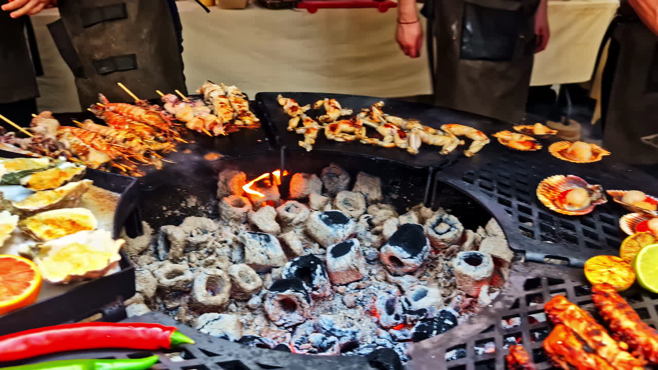 Grilled seafood including octopus and scallops on round coal-fired market grill