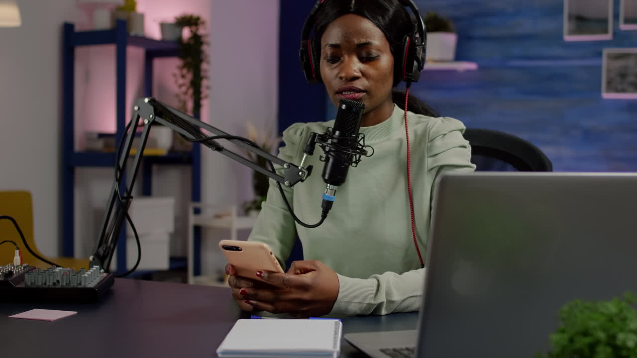 African vlogger recording video blog reading messages from smartphone