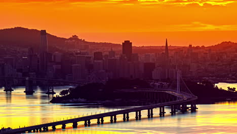 time lapse, red and yellow colors above san francisco usa, evening sunlight, downtown buildings and oakland bridge traffic