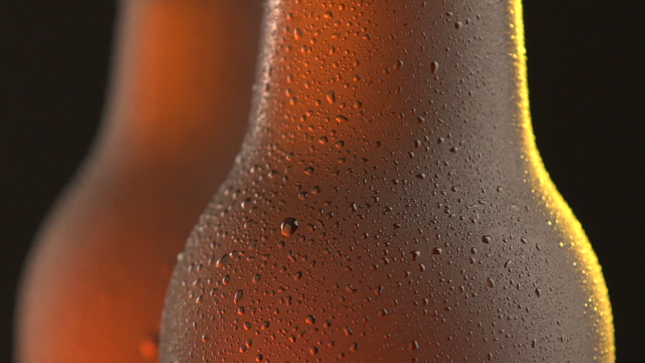 Two beer bottle rotating on black background