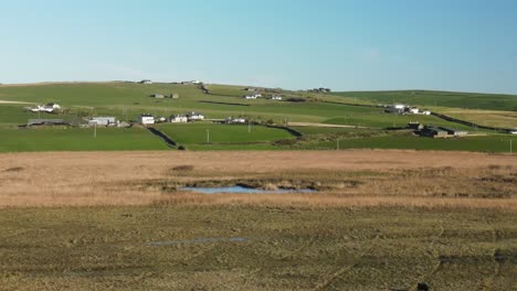 Winter-morning-in-a-countryside-Ireland,-near-pitch-and-putt-field-and-distant-farms-with-blue-sky