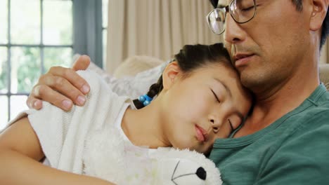 아버지와 딸이 거실 4k의 소파에서 휴식을 취하고 있습니다.