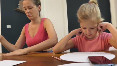 mother and daughter drawing together at home