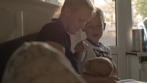 mother with baby daughter and elder son at home