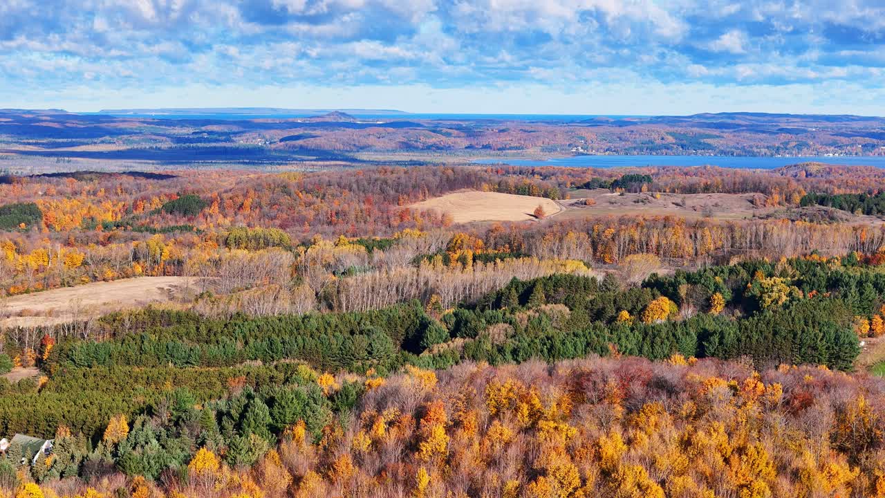 Syksyiset värit peittävät metsiä ja kukkuloita järven ympärillä lähellä Traverse Cityä, Michiganissa, USA:ssa.
