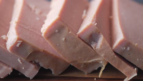 close up of slice of canned meat on a chopping board