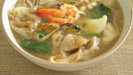 wide rice noodles with seafood in gravy sauce - asian food style