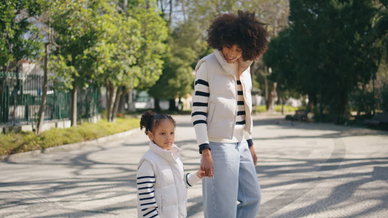 Happy mother walking daughter at family weekend. Girl going with woman.