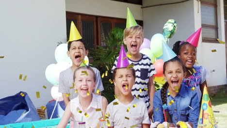 crianças vestindo chapéus de festa celebrando com animação de confete sobre eles