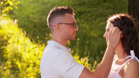 Hombre-Colocando-Margaritas-En-El-Cabello-De-Una-Mujer-En-Un-Parque-De-Verano.-Concepto-De-Ocio,-Vacaciones-Y-Personas.-Hombre-Joven-Feliz-Colocando-Margaritas-En-El-Cabello-De-Una-Mujer-En-Un-Parque-De-Verano.