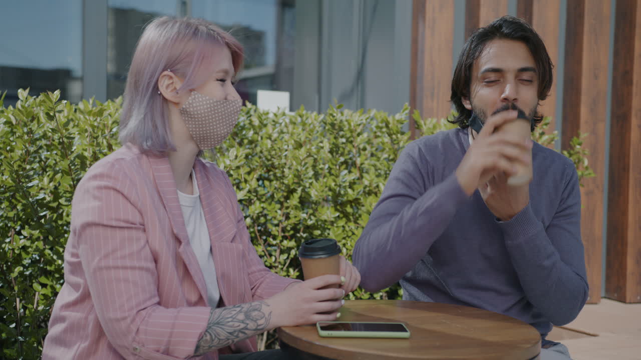 Couple having coffee outdoors during pandemic
