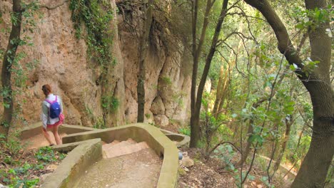 excursionista con mochila camina por escalones de piedra en el bosque de la isla de capri, italia - ángulo alto