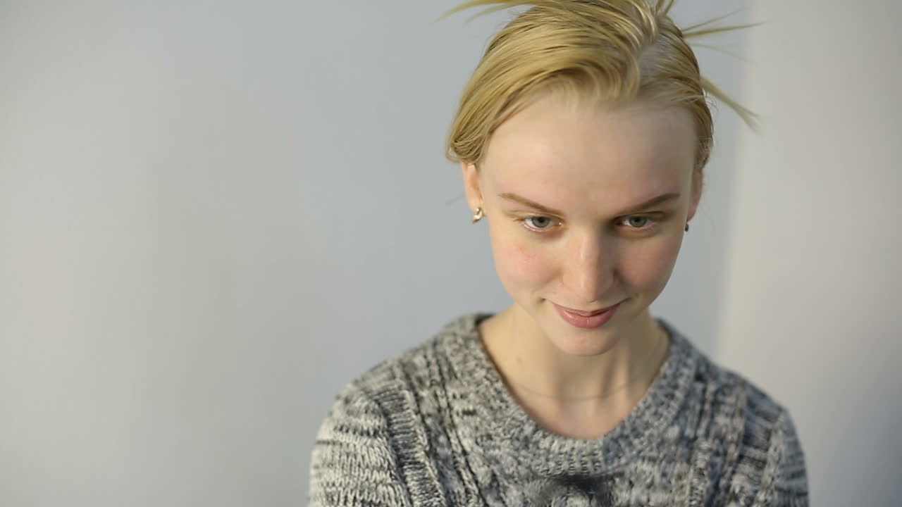 Woman looking in mirror. Patient looking at herself in the mirror after permanent eyebrow procedure