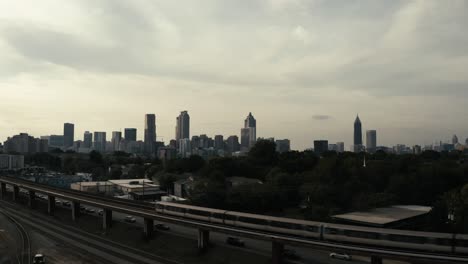 Der-U-Bahn-Zug-Marta-In-Atlanta,-Georgia,-Fährt-Im-Vordergrund-Einer-Wunderschönen-Luftaufnahme-Der-Skyline-Der-Innenstadt-Von-Atlanta-Vorbei