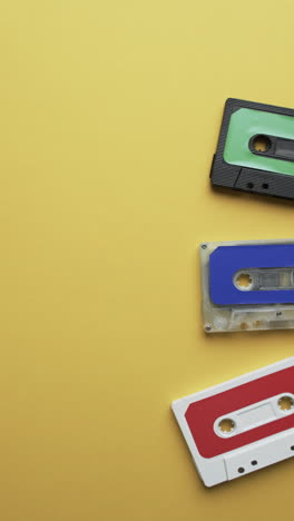 vertical video of retro tapes with copy space on yellow background
