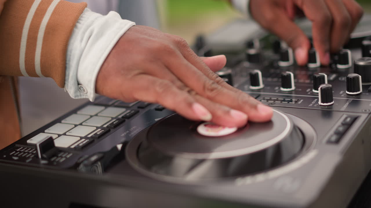 Performance di DJ energica all'aperto, DJ dinamico che mixa melodie ritmiche colorate dal vivo all'aperto, atto musicale vivido con mani che controllano abilmente i giradischi a un energico festival all'aperto.