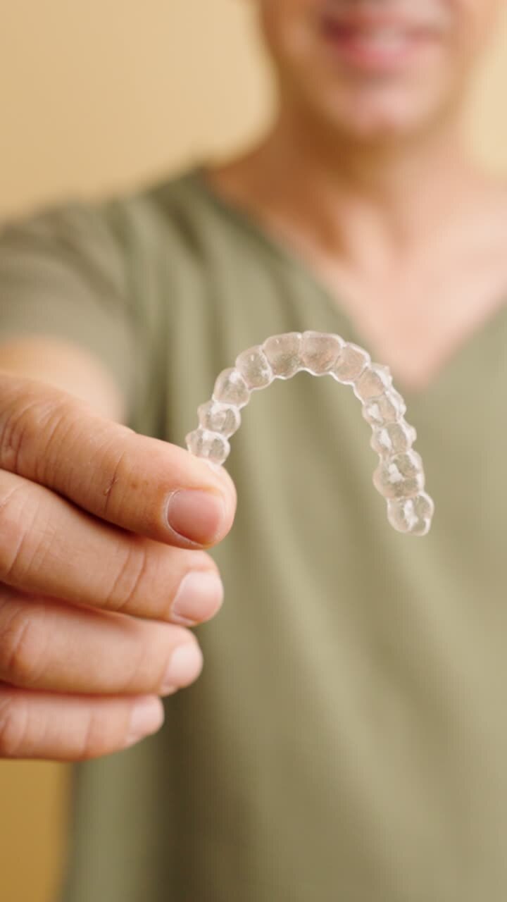 Person holding Invisalign aligners