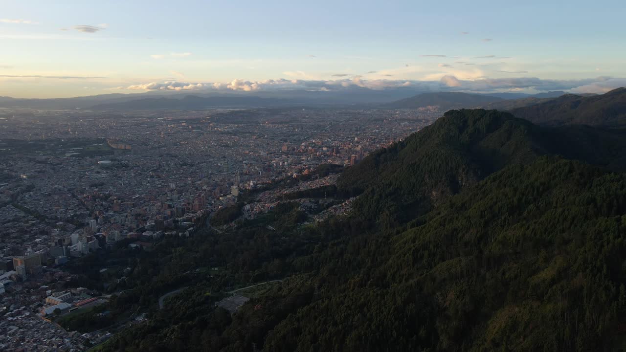Aerial establishing stunning overview from Cerro de Monserrate in Bogotá at sunset, iconic church and panoramic views of Bogota Colombia