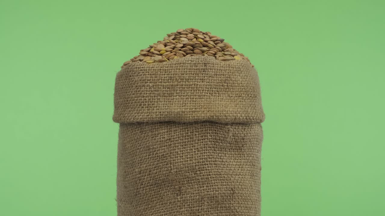 Rotating a full bag of lentil grain. Close-up.