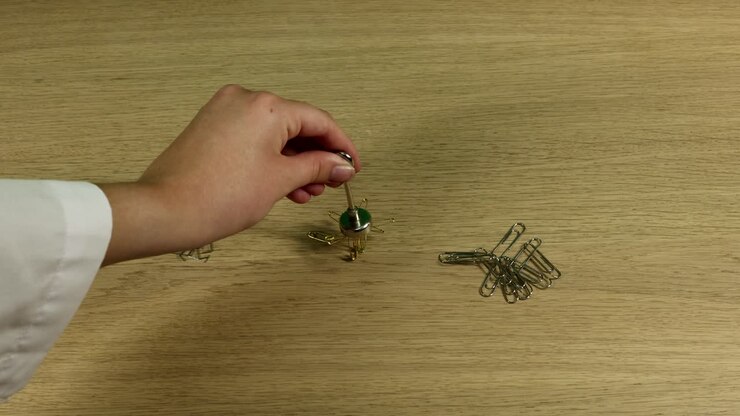 Hands constructing a miniature metal helicopter