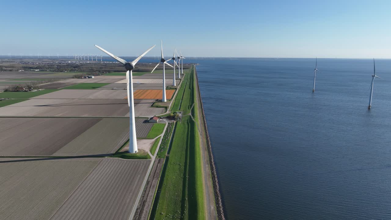 wind turbine along the water line. Renewable energy, clean energy, energy transistion. Aerial drone video.
