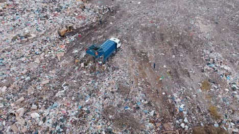 aerial view of landfill with garbage truck and workers