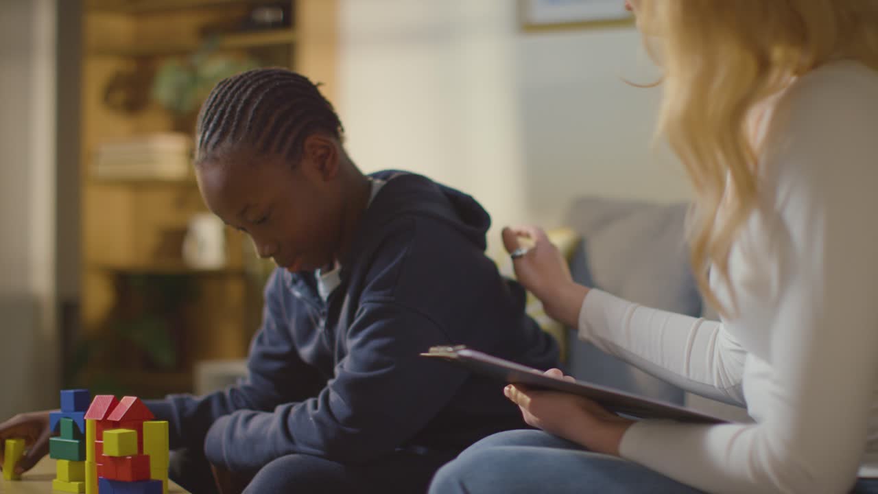 niño en el espectro del tda siendo ayudado o evaluado por una maestra o psicóloga educativa en casa 7