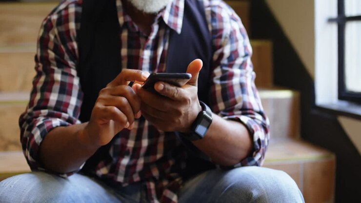 Senior man sitting on the staircase and typing a text message on the phone 4K 4k