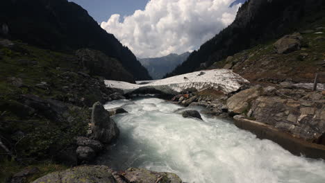 mountain river and snow melt in alpine valley