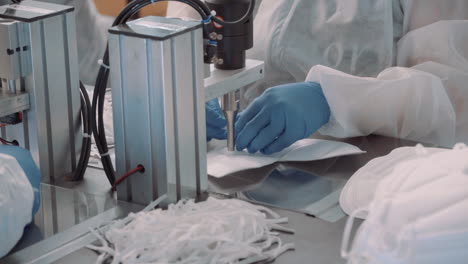 gluing the elastics to face masks, workers perform the operation with an automatic machine