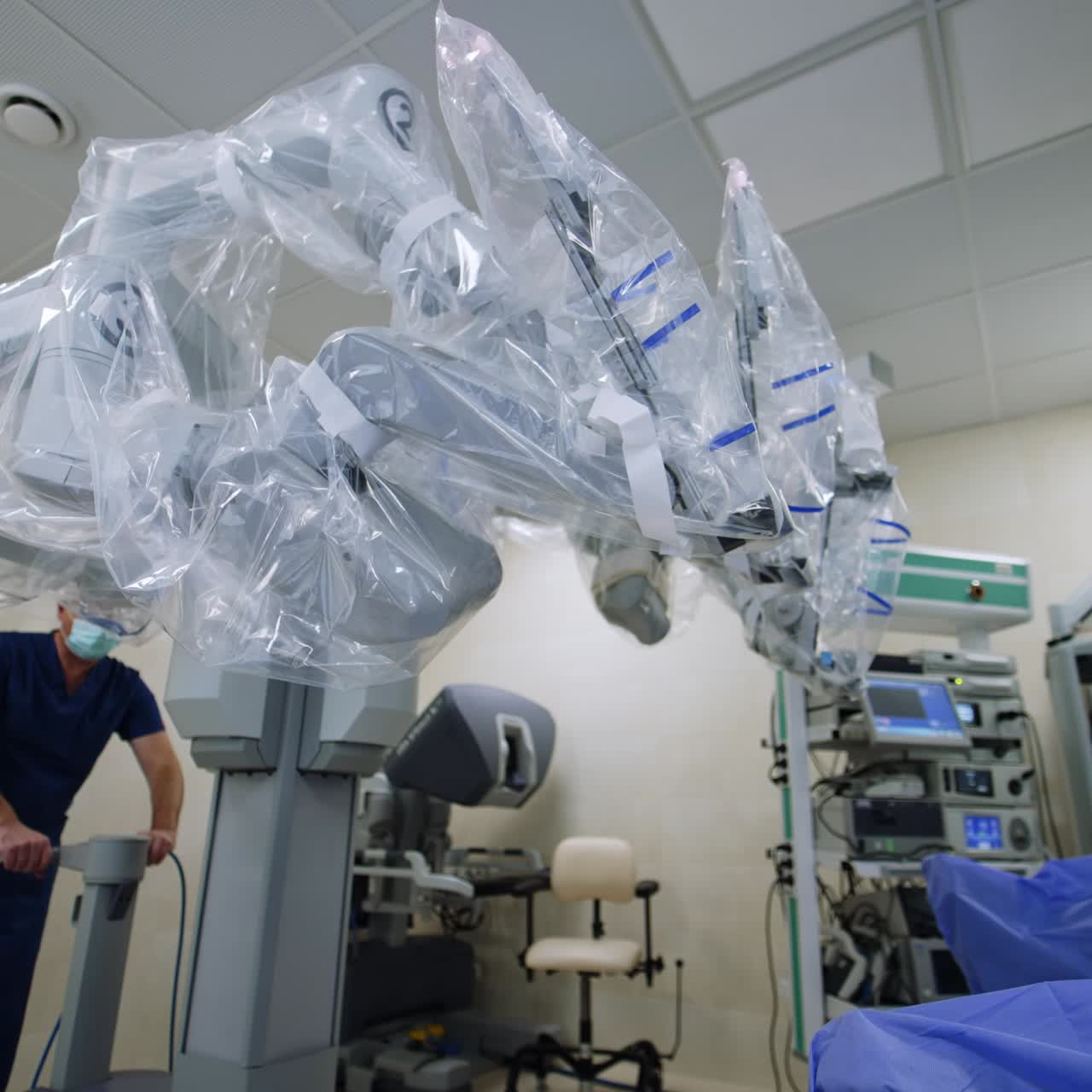 Da Vinci robot surgeon is moved closer to an operational table. Futuristic equipment is prepared for the surgery