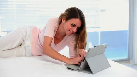 Pretty-woman-lying-and-using-her-tablet-pc