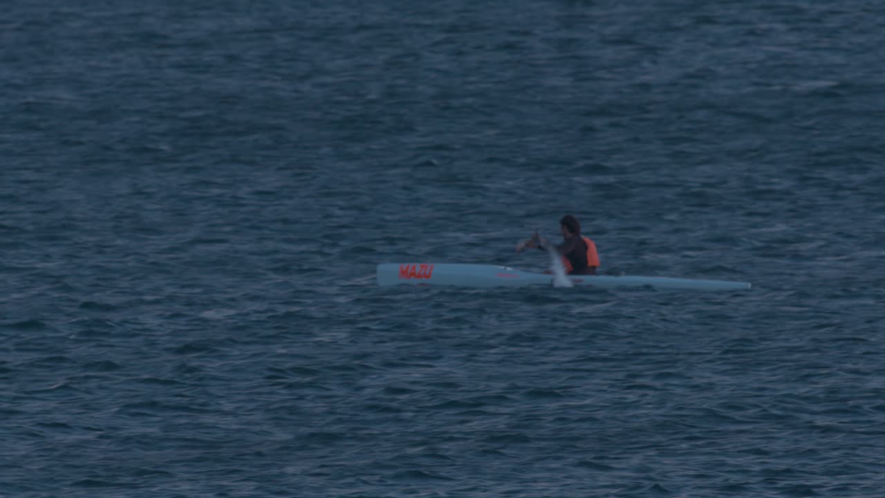 hombres practicando piragüismo en el océano, en cascais al atardecer