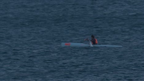 hombres practicando piragüismo en el océano, en cascais al atardecer