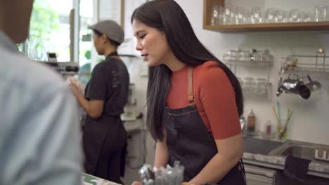 coffee shop owners are taking orders from customers and telling baristas to make menus ordered by customers. lgbt customers are looking at the menu and ordering coffee in coffee shop concept