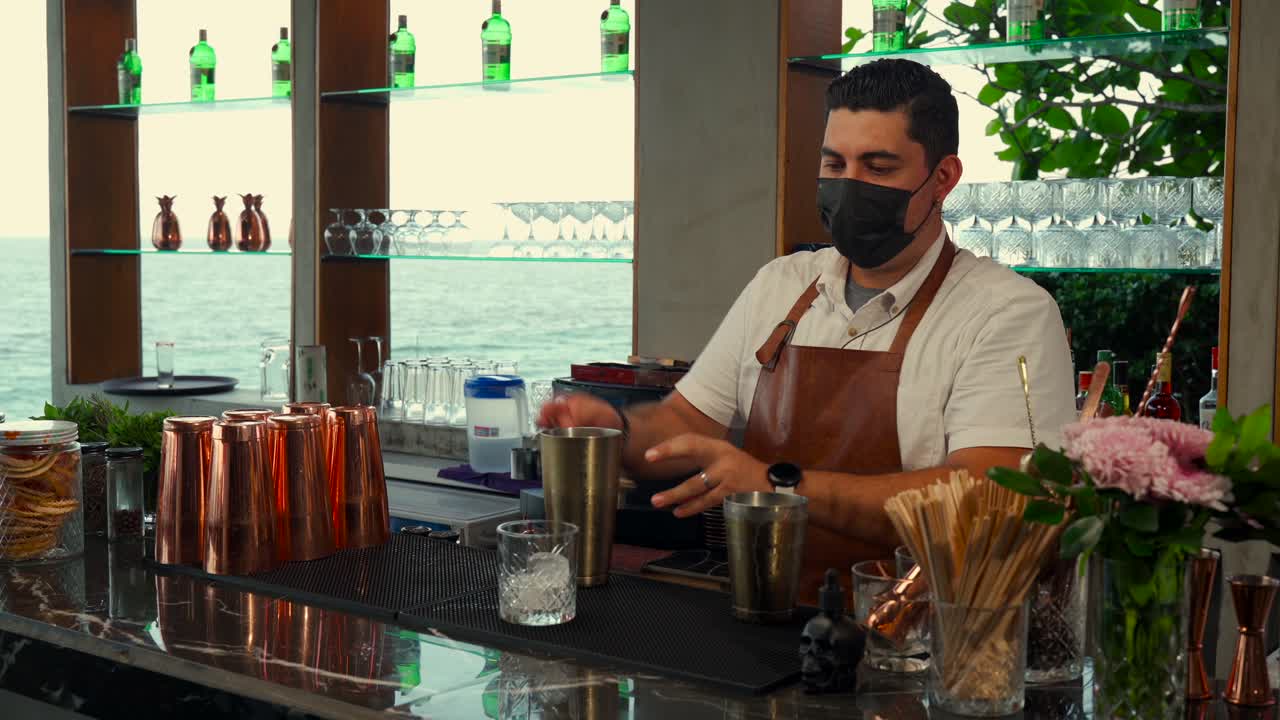 bartender latino preparando carajillo café bebida cóctel con estilo espectáculo de rutina en la bahía frente a la playa restaurante bart vacaciones en el caribe disfrutar
