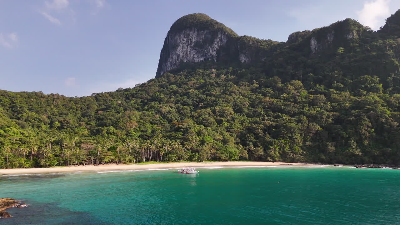 Stunning drone shot of El Nido, Philippines, highlighting its white sandy beaches and lush forested landscapes in a tropical paradise. Wide shot.
