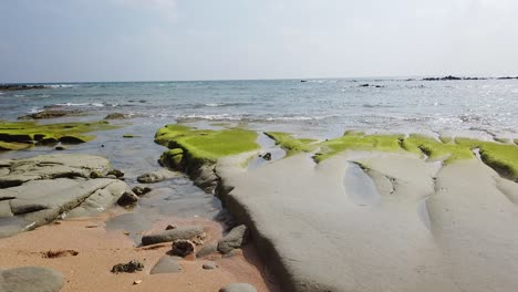 Seitliche-Bewegung-Entlang-Des-Strandes-Einer-Abgelegenen-Andamaneninsel-Mit-Erosion-Von-Altem-Vulkangestein-Bei-Ebbe-Mit-Algen-Und-Riffen