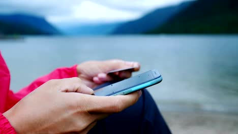 close up hands holding credit card and using mobile smart phone outdoor.