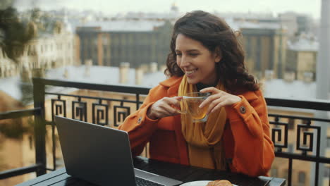 woman video calling on laptop on rooftop terrace