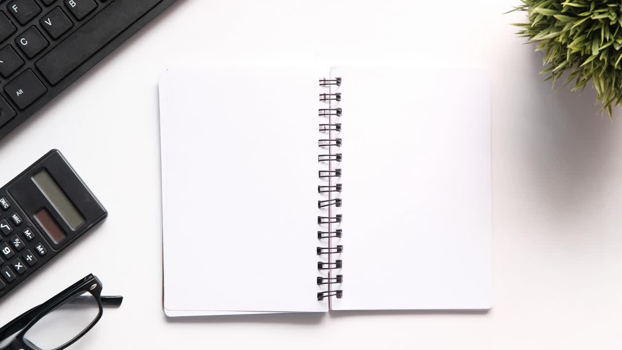 Organized Workspace with Notebook, Calculator, and Glasses