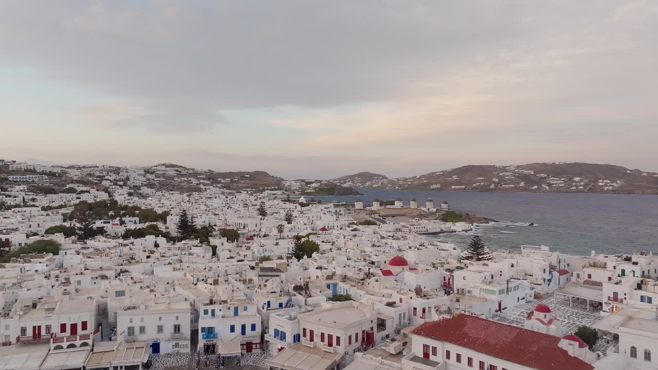 Isola di Mykonos al tramonto, ville di lusso in stile cicladico sul mare e case cubiche imbiancate a calce, Mar Egeo, Paralia, Cicladi, ripresa aerea con drone