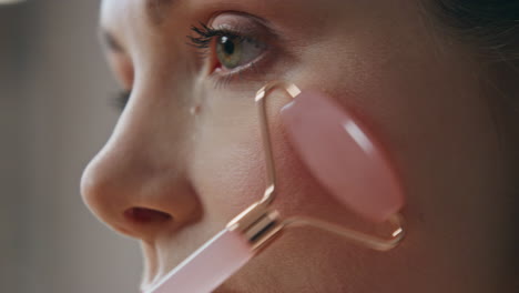 Woman using facial massage roller for skincare