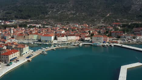 aerial pan and boom shot over a coastal town on cres island, croatia on a bright clear day.