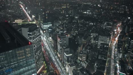 congested road and illuminated high-rise buildings in shibuya, tokyo in the evening - high angle, real-time