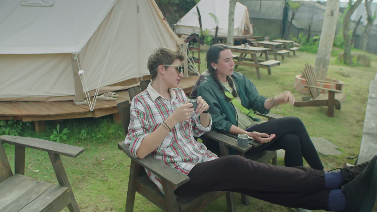 Two Female Tourists Relaxing at Glamping and Discussing Nature View
