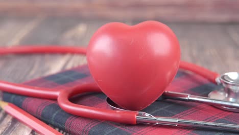 medical equipment with a red heart and stethoscope on a wooden table