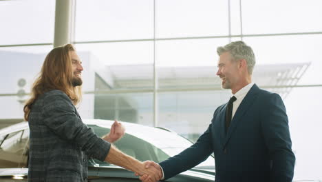 car dealership customer and salesperson handshake