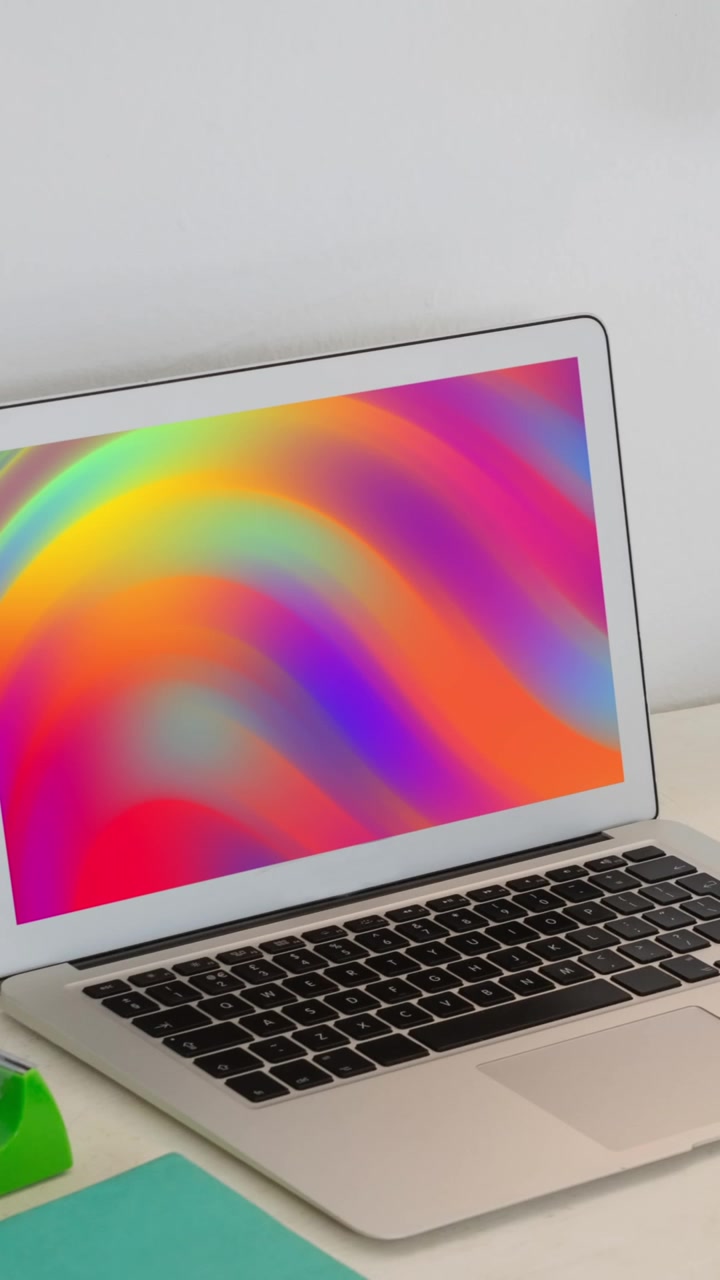 Animazione di laptop con forme colorate in movimento sullo schermo sulla scrivania