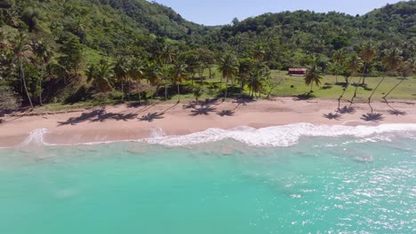 Olas-Del-Océano-Verde-Turquesa-Aterrizando-En-Una-Playa-De-Arena-Tropical,-Aérea-De-Lado